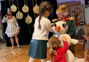 Zdjęcie przedstawia dzieci biorąc udział w zabawie pt. "zadanie dla Świętego Mikołaja- Lepimy bałwana".