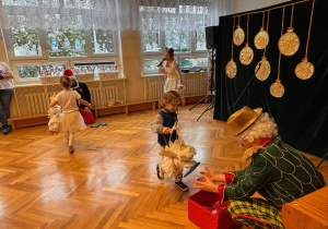 Zdjęcie przedstawia dzieci realizujące zadanie dla Swiętgo Mikołaja- Aniołki przenoszą kolorowe