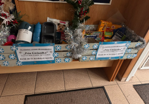 zdjęcie przedstawia dwa lekko szare drewniane kosze z zebranymi darami podczas akcji Przedszkolnego wolontariatu "Psia gwiazdka"